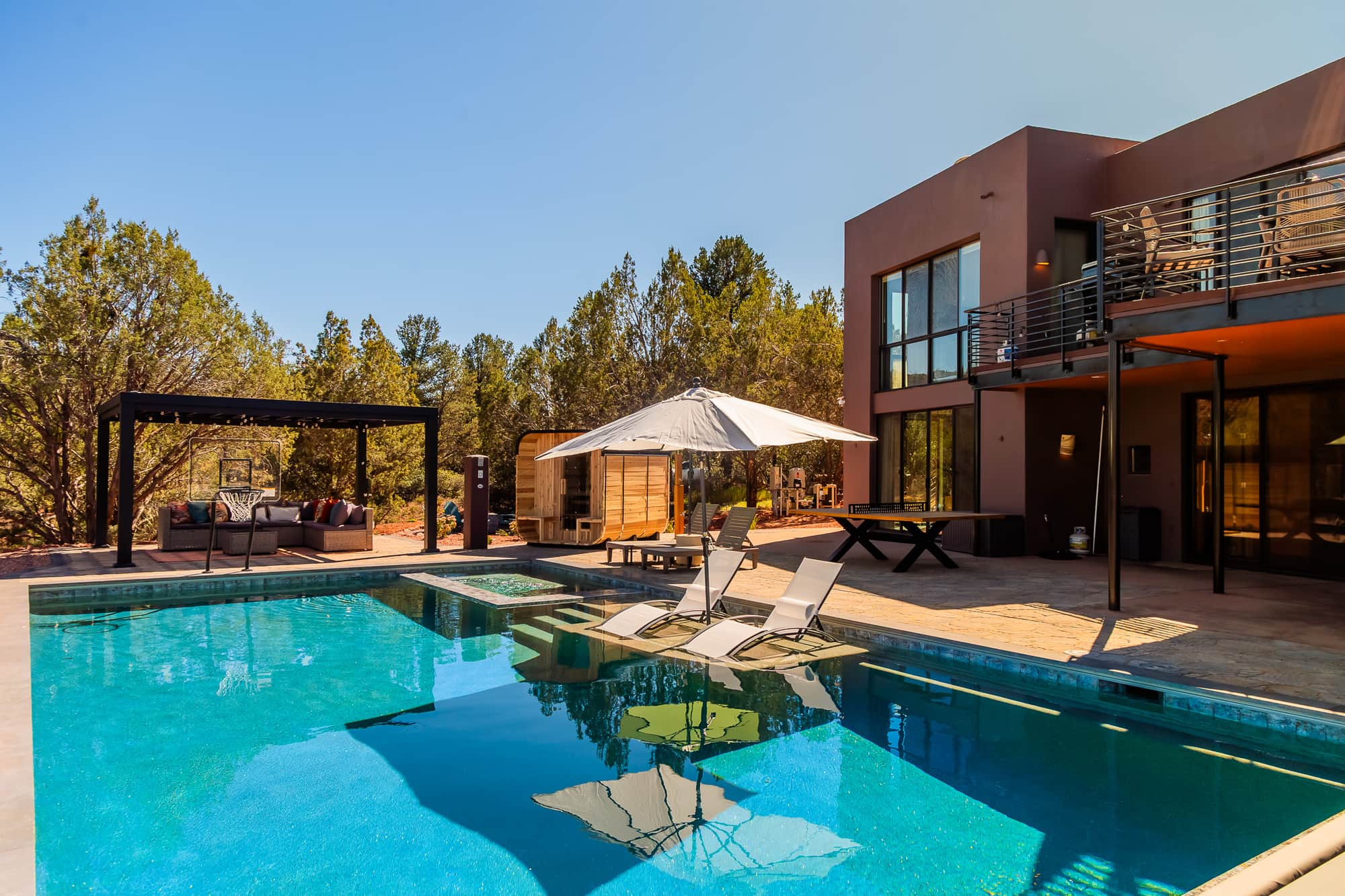 The pool by day, wide view with umbrellas and red rock